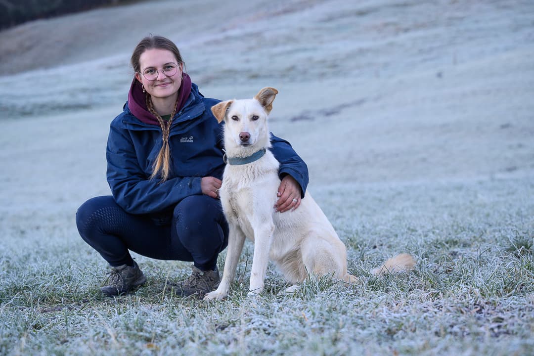 Agnès Philipona auprès d'un chien blanc dans le domaine