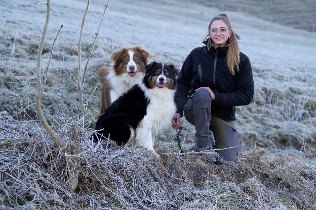 Lara Sudan accompagnée de deux chiens dans un pré givré